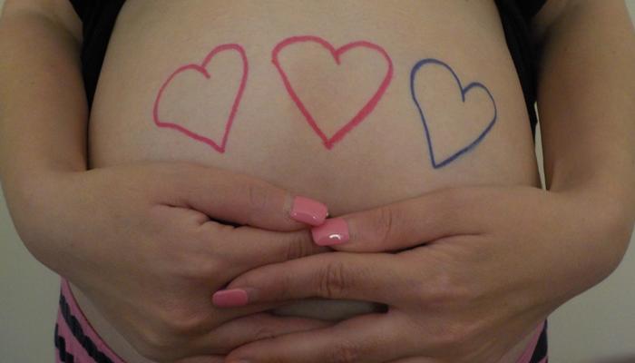 Pregnant tummy with hearts drawn on it