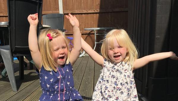 Happy twin girls outside in the sunshine