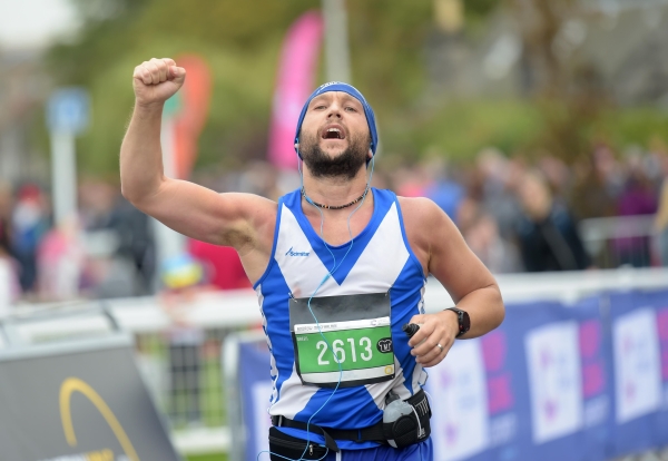 man with fist in the air running the Scottish 10k