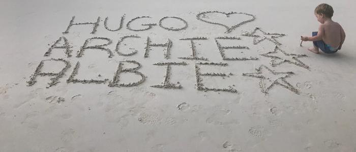 Babies names drawn in the sand