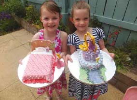 twin girls with their own birthday cakes