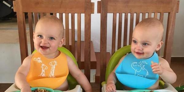 Twins eating in high chairs