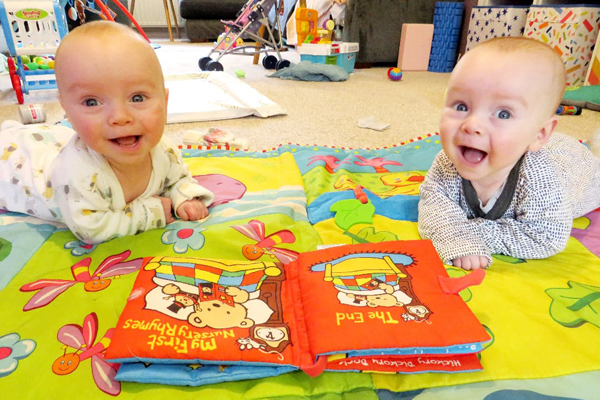 Two twins facing the camera and laughing