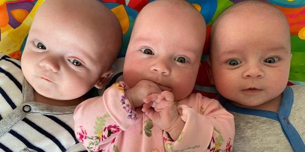 Triplet babies on a playmat