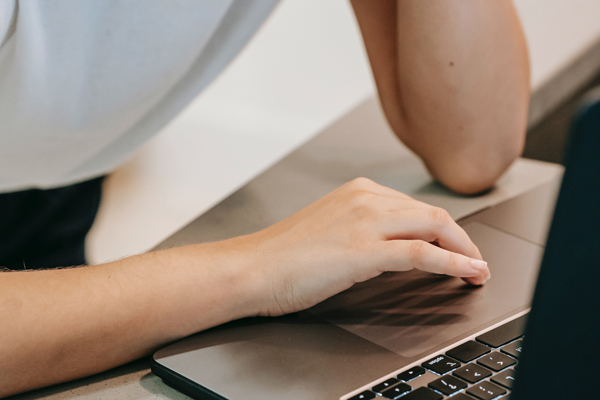 Cropped picture of a woman's arms leaning on a laptop