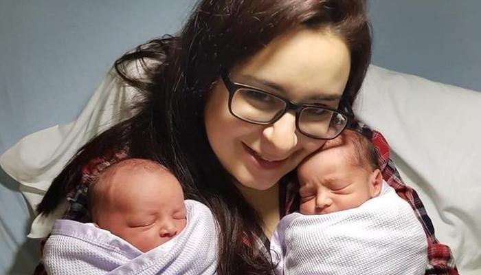 A women cuddling her twin babies