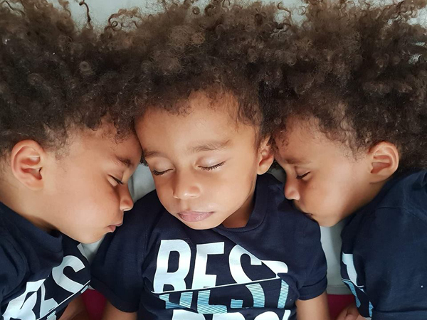 A set of triplets sleeping next to each other