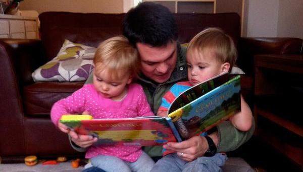 Dad reading his twins a story