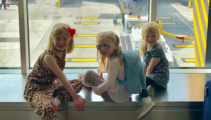 Twin girls and older sister at the airport
